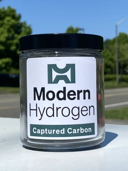 Methane pyrolysis produces carbon black, a black powder shown in this canister labeled with the Modern Hydrogen logo