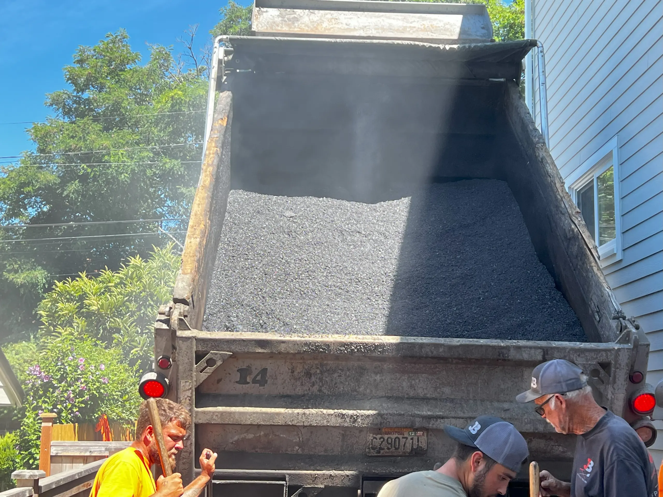 Higher Temperatures can affect asphalt. Modern Asphalt can handle the heat. Truck of HMA being poured onto a private driveway.